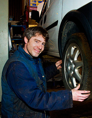 Automotive Engineer fitting tyre in Vehicle Maintenance Bay